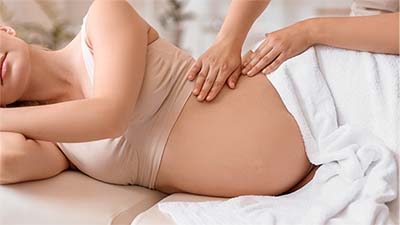 Close-up of hands providing a calming prenatal massage, supporting relaxation and pain relief for an expecting mother at 12th Avenue Massage Therapy Group in Pensacola.